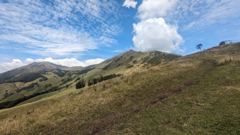 grassy hills under clouds