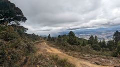 dirt trail with city and hills in distance