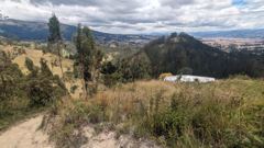 dry hillside road with city and hills